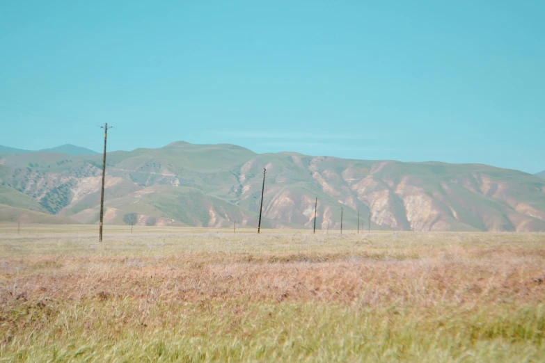 some telephone poles sitting in an open field