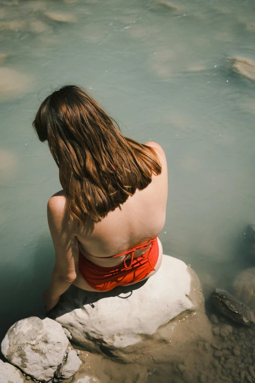 a person that is sitting down near a body of water