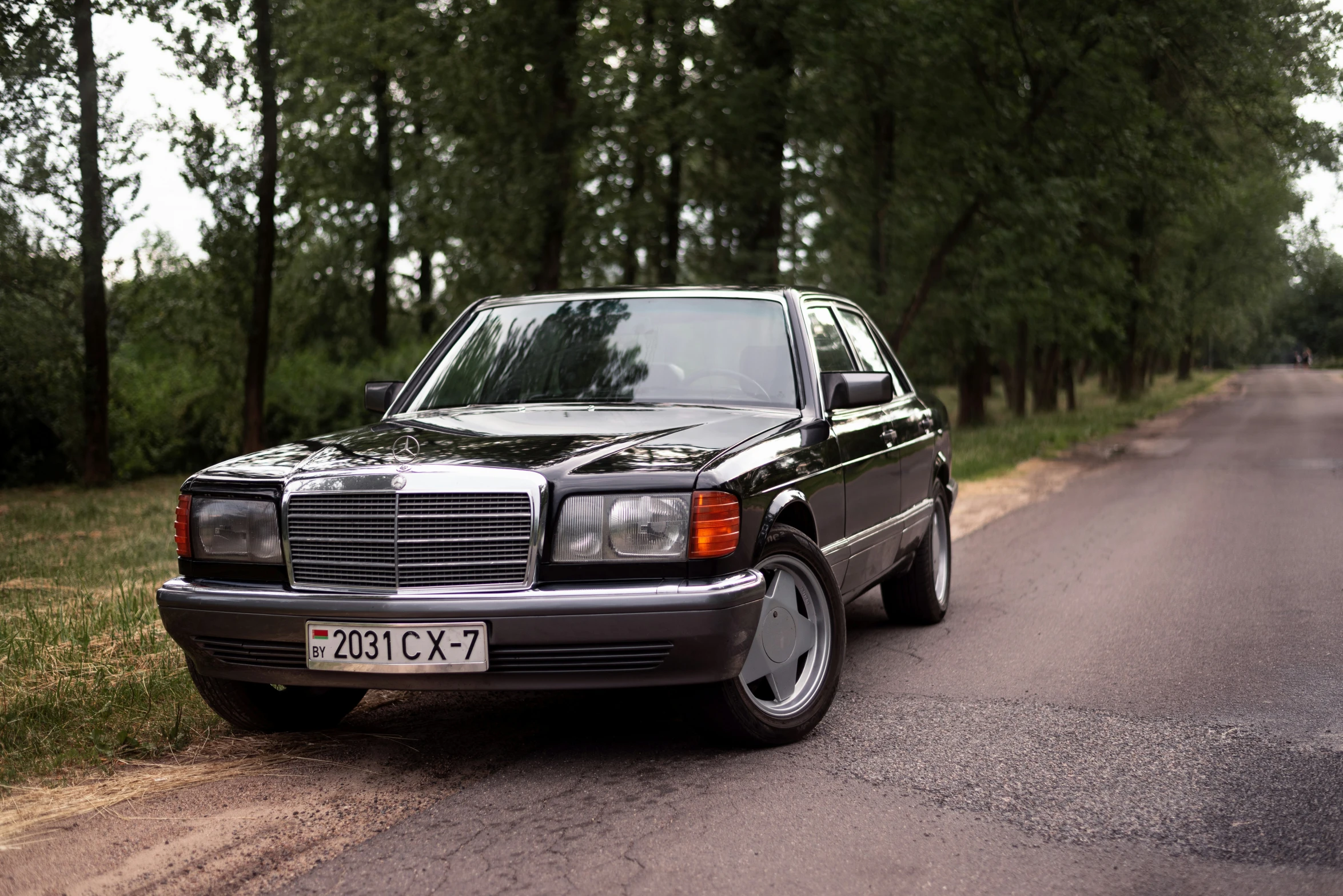 a mercedes benz is parked on a country road