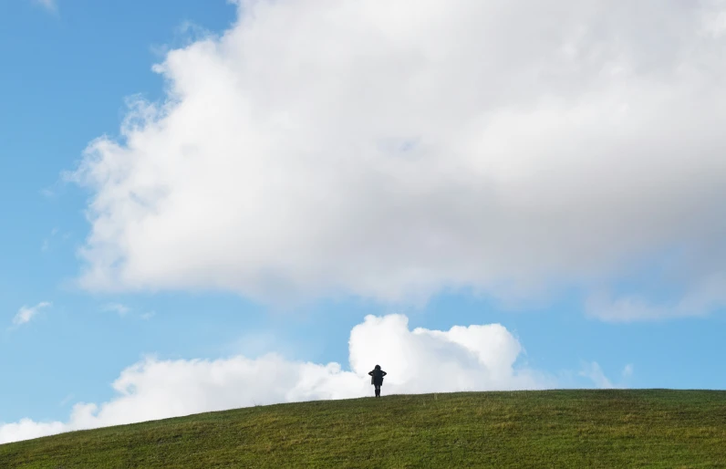 the person is flying a kite on top of the hill