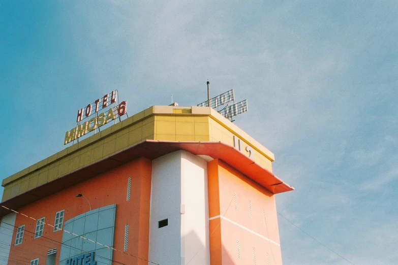 the roof of an orange and white building against a blue sky