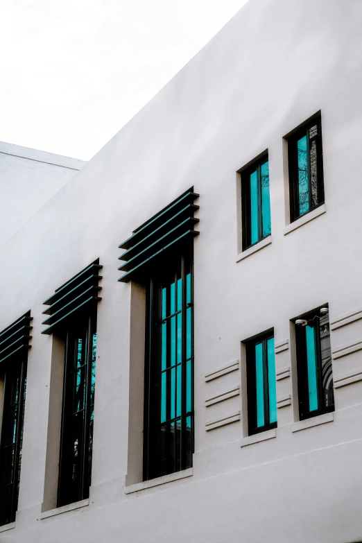 a large white building with black trim and green windows