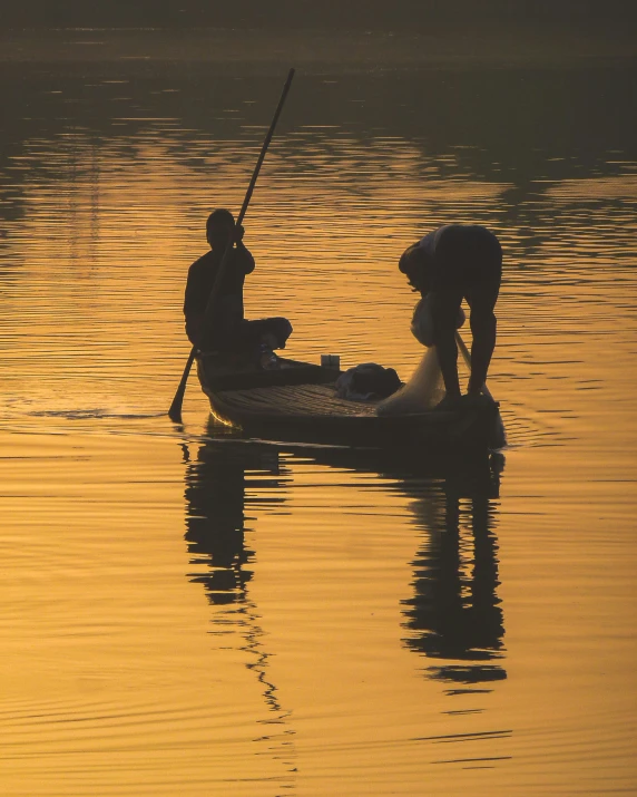 two people in a boat that has a pole