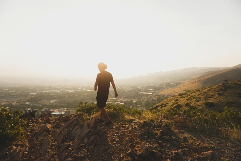 a person standing on a rock with a view of the valley below