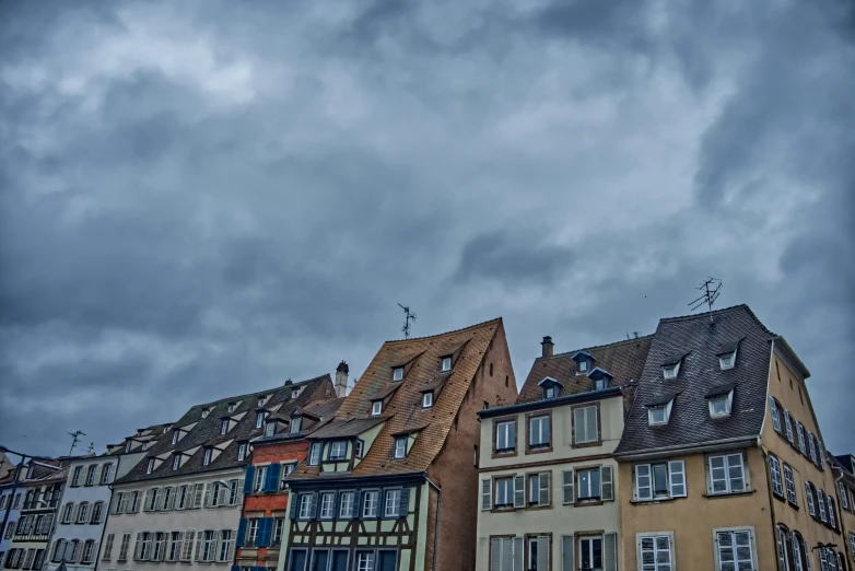 a row of older buildings sitting next to each other under a cloudy sky