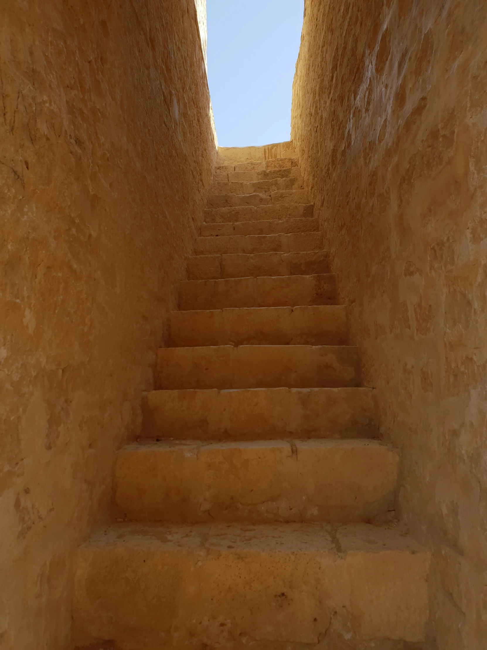 a stone staircase is leading up to a skylight