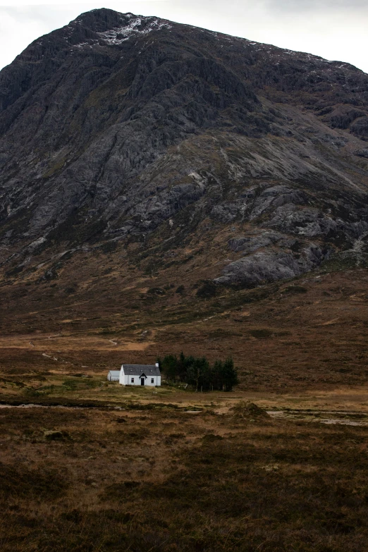 an image of a hut nestled in the mountains