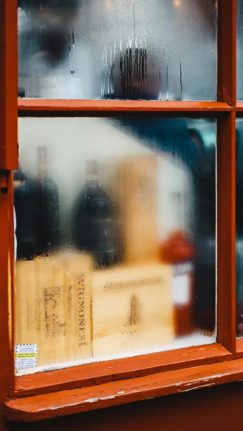 a window that has some water and a yellow container outside it