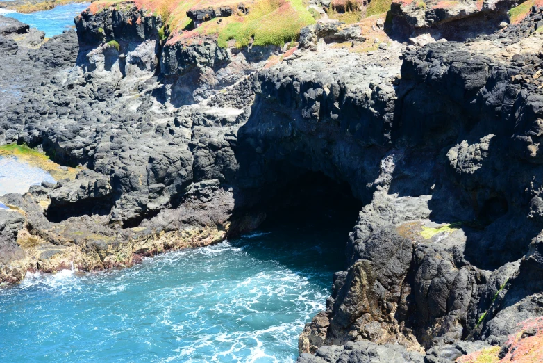 black rocks are separated by water and grass