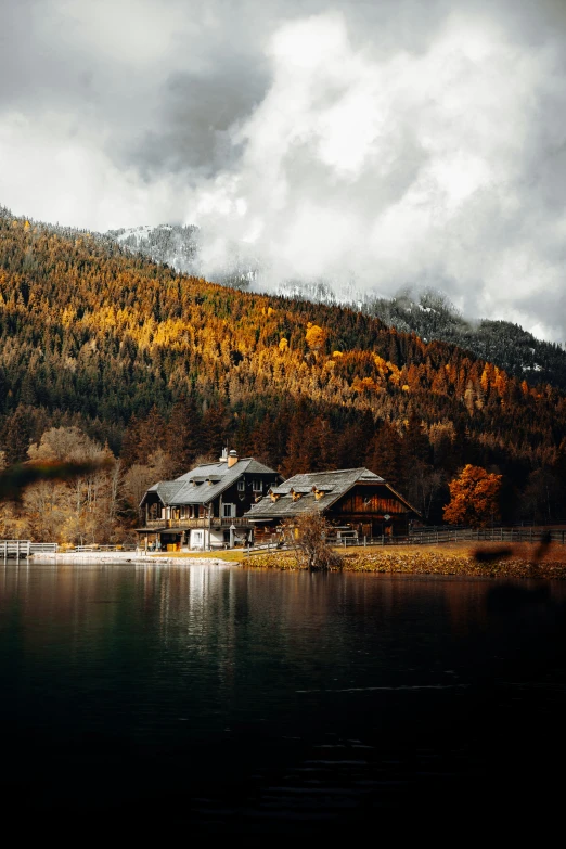 the house is sitting on the shore of the lake