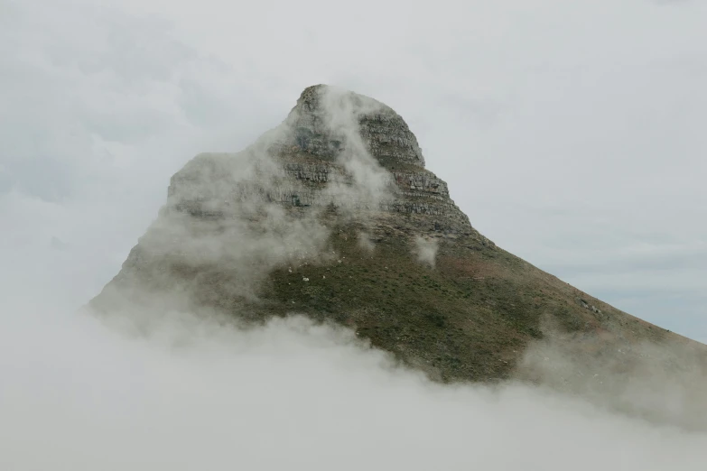 a very tall mountain peak in the middle of clouds