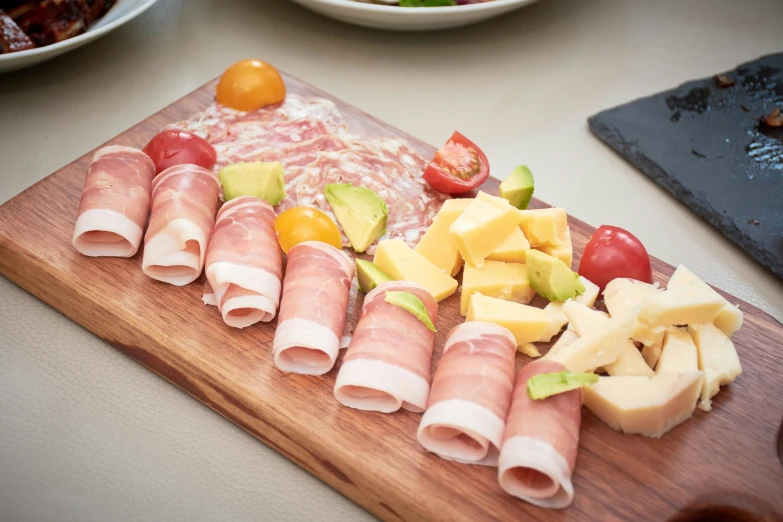 a  board with various slices of meat and cheese on it