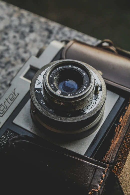 an old fashioned camera next to a leather case