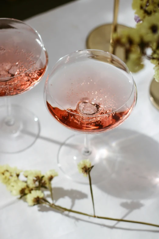 a close up view of two wine glasses on the table