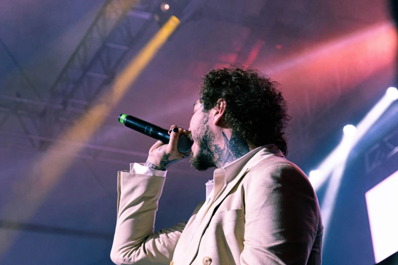 a bearded man is performing with a microphone