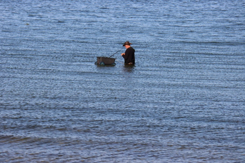 a man stands in water holding an object