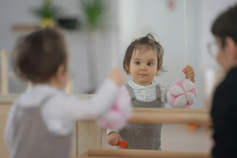 a little girl standing in front of a mirror