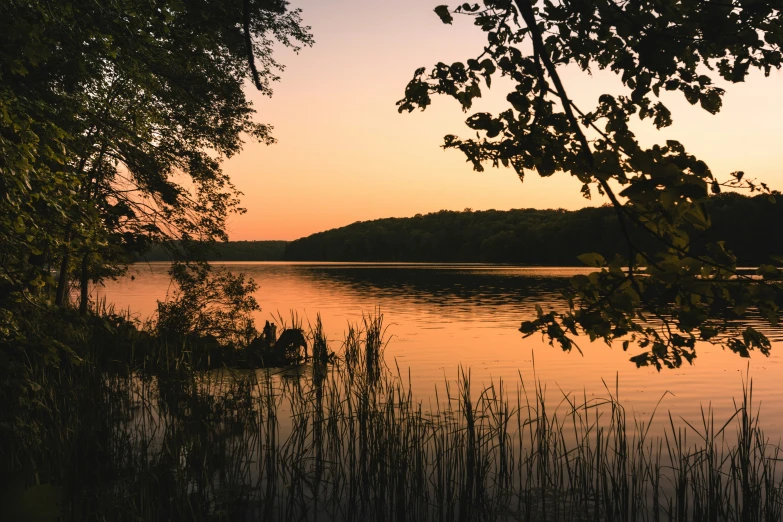 the sun is setting on a small body of water