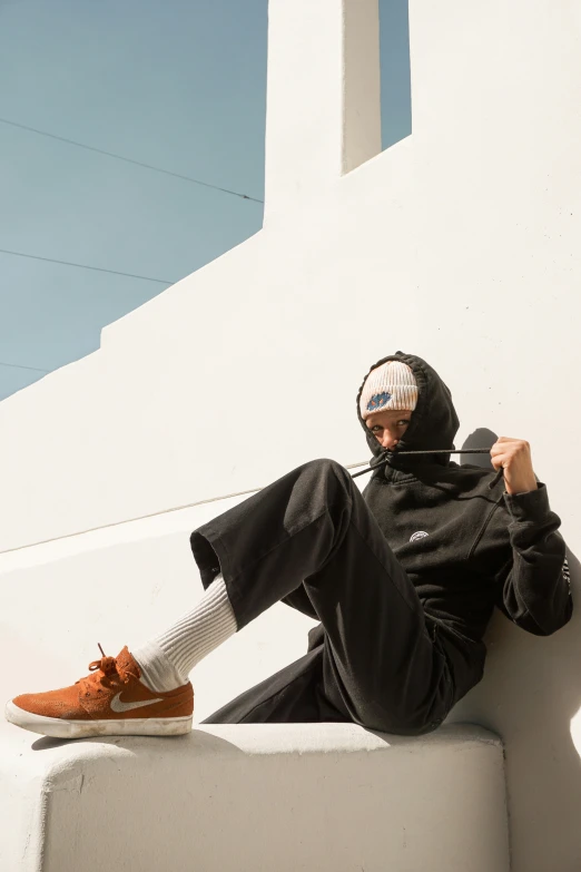 person wearing a hoodie sitting on white ledge