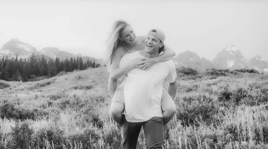 black and white pograph of a man and woman emcing in a field of grass