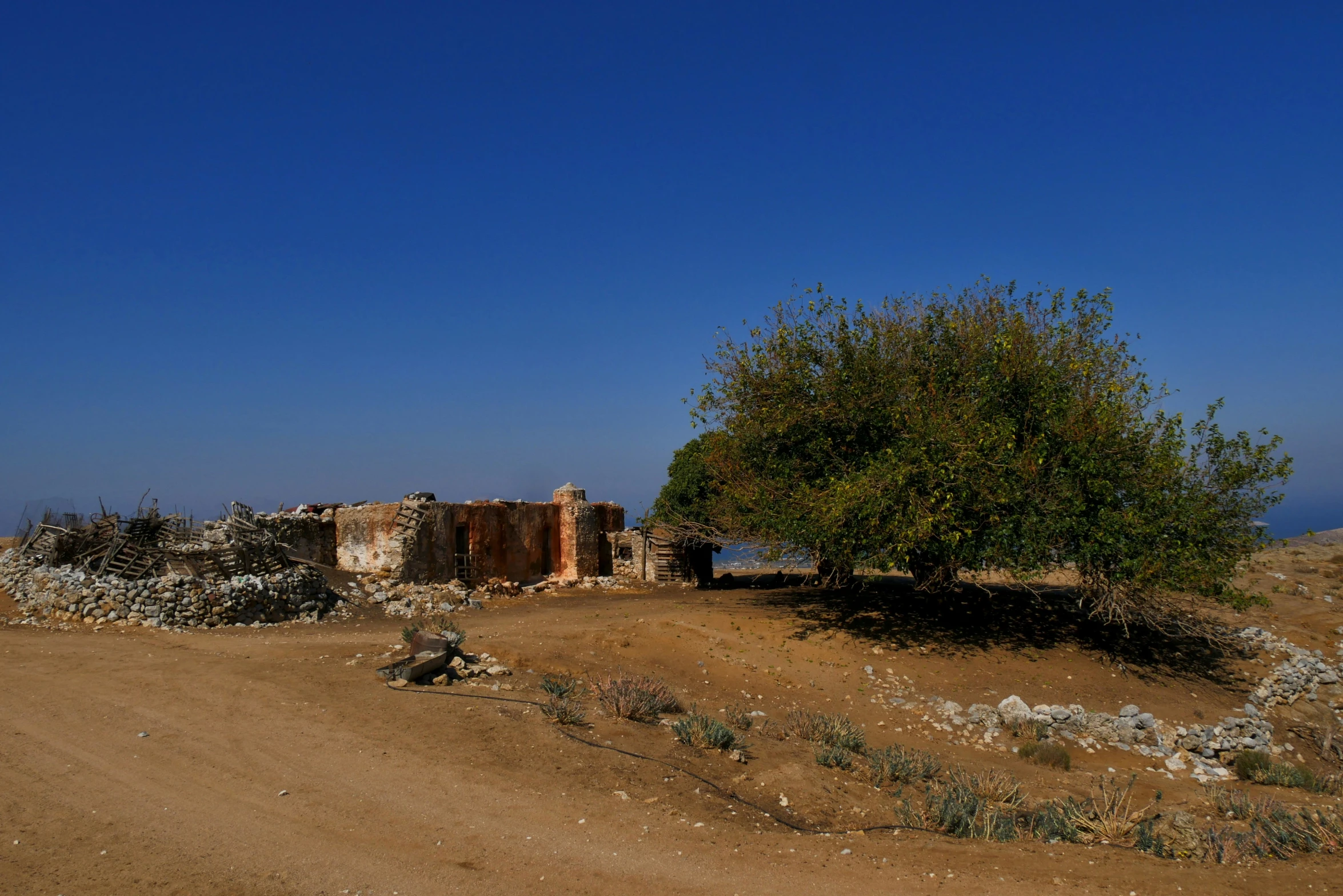 an old building sits in the middle of a dirt road