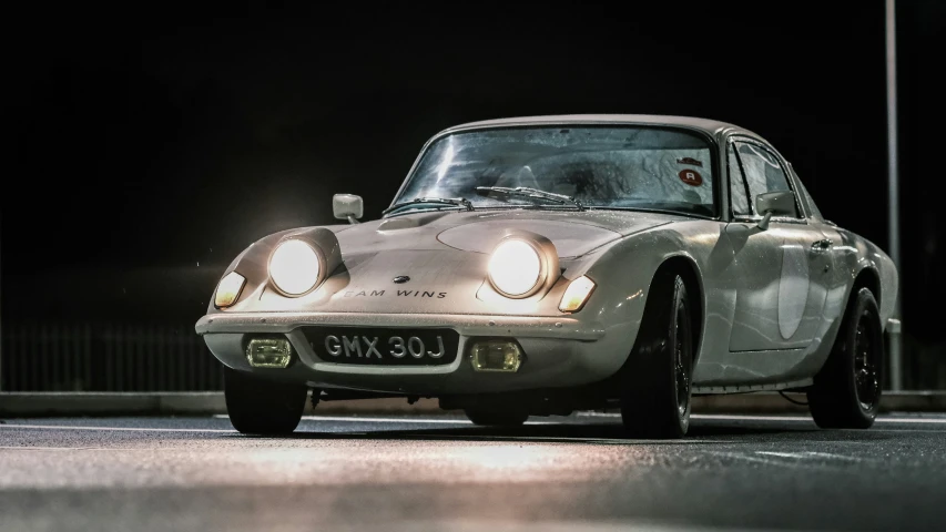 an old porsche dino is driving on the street