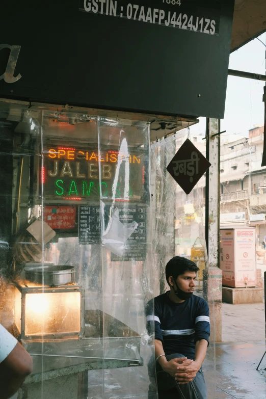 a man sitting on a ledge next to a store