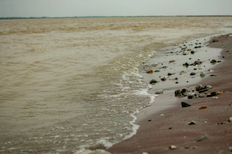 some rocks in the water on a beach