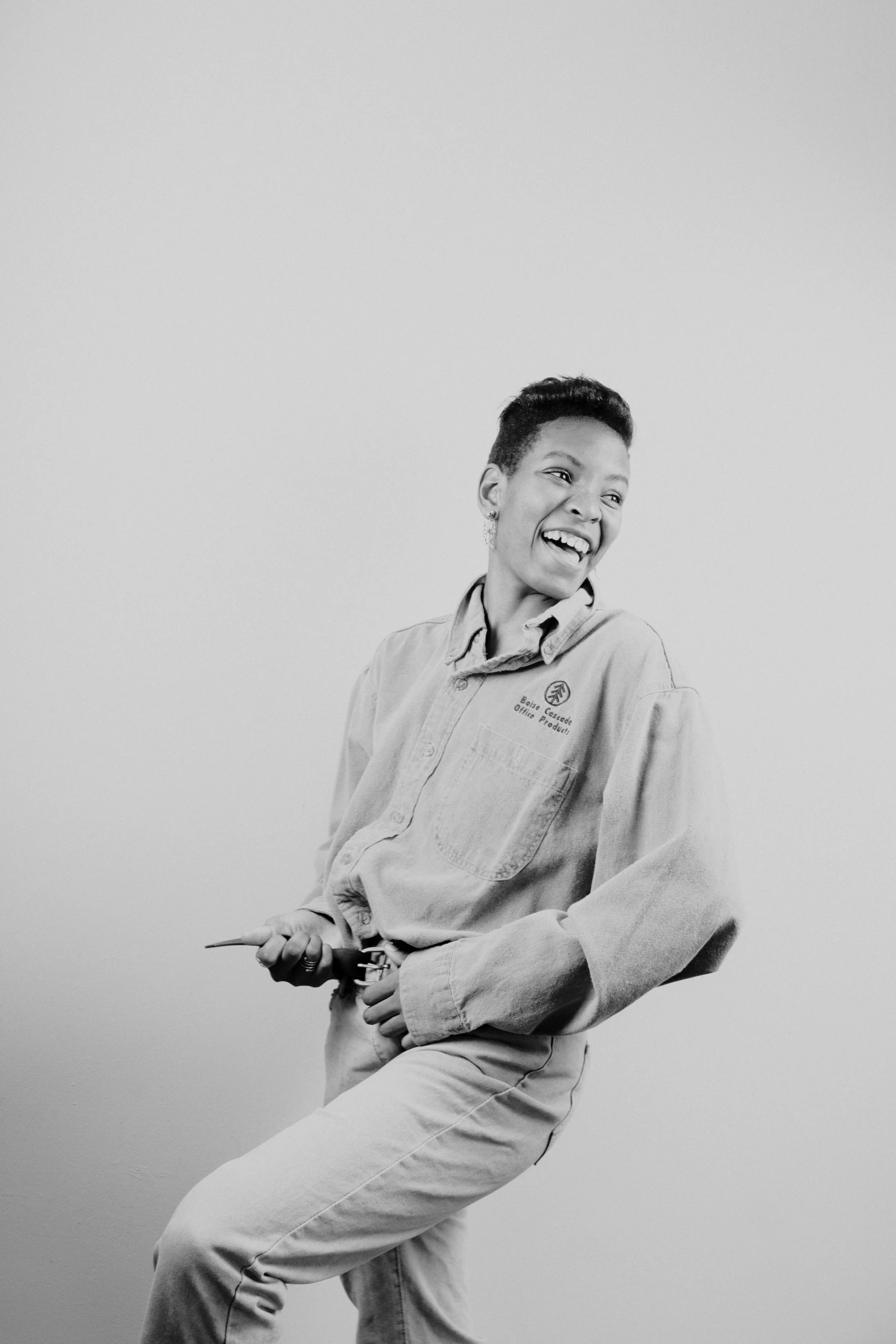 man holding scissors and laughing in white room