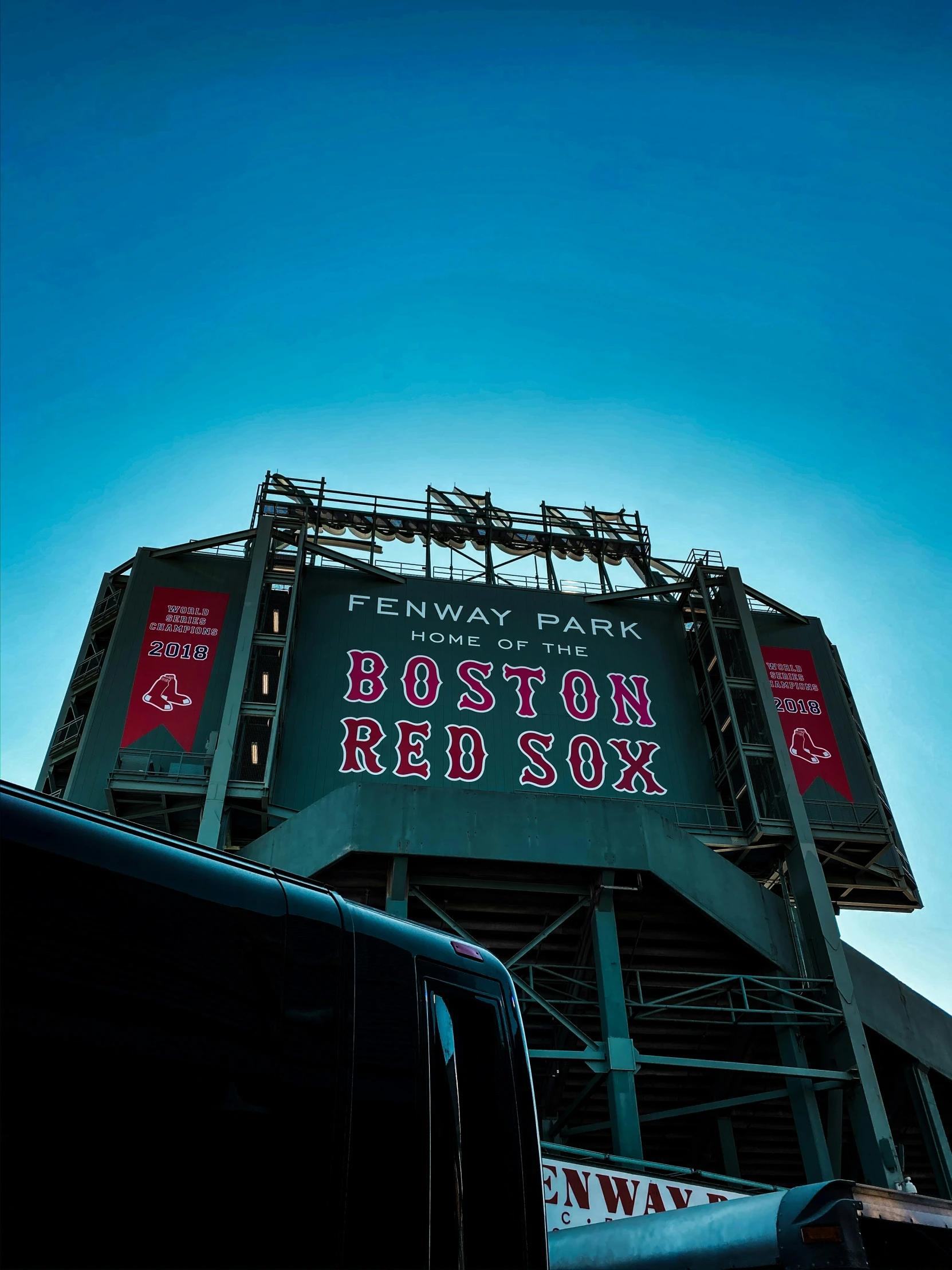 the truck is driving under the sign at the baseball field