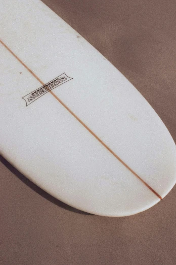 white surfboard lying on the sand and brown ground