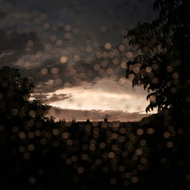 a rain soaked window looking at the sky and clouds