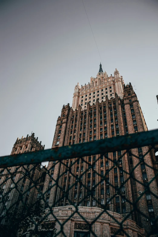 the tall building is visible through the fence