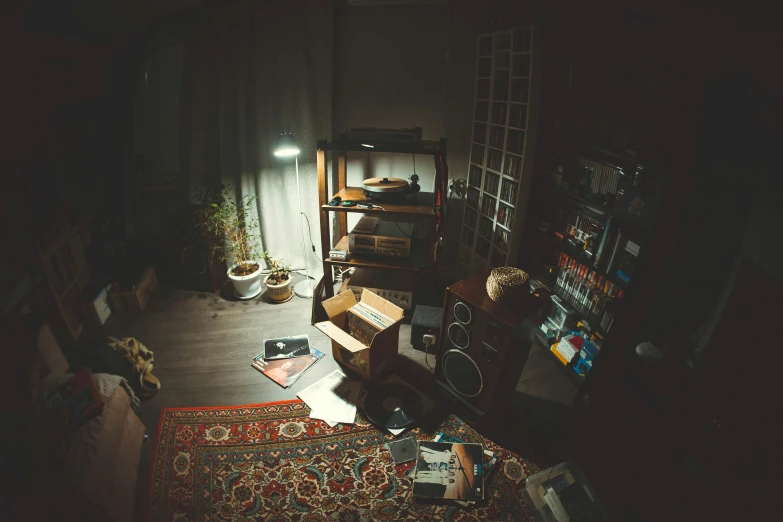 a room full of rugs, boxes and a shelf with a lamp on it