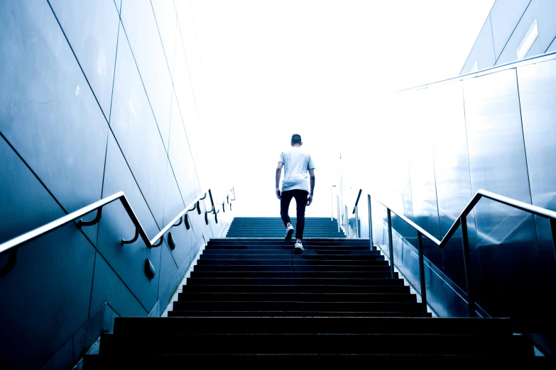 man in white shirt walking down the stairs