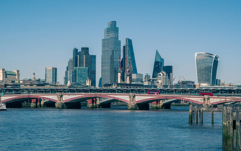 a river with a bridge and a large city in the background