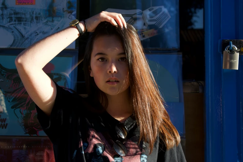 a woman holding her hair and posing for the camera