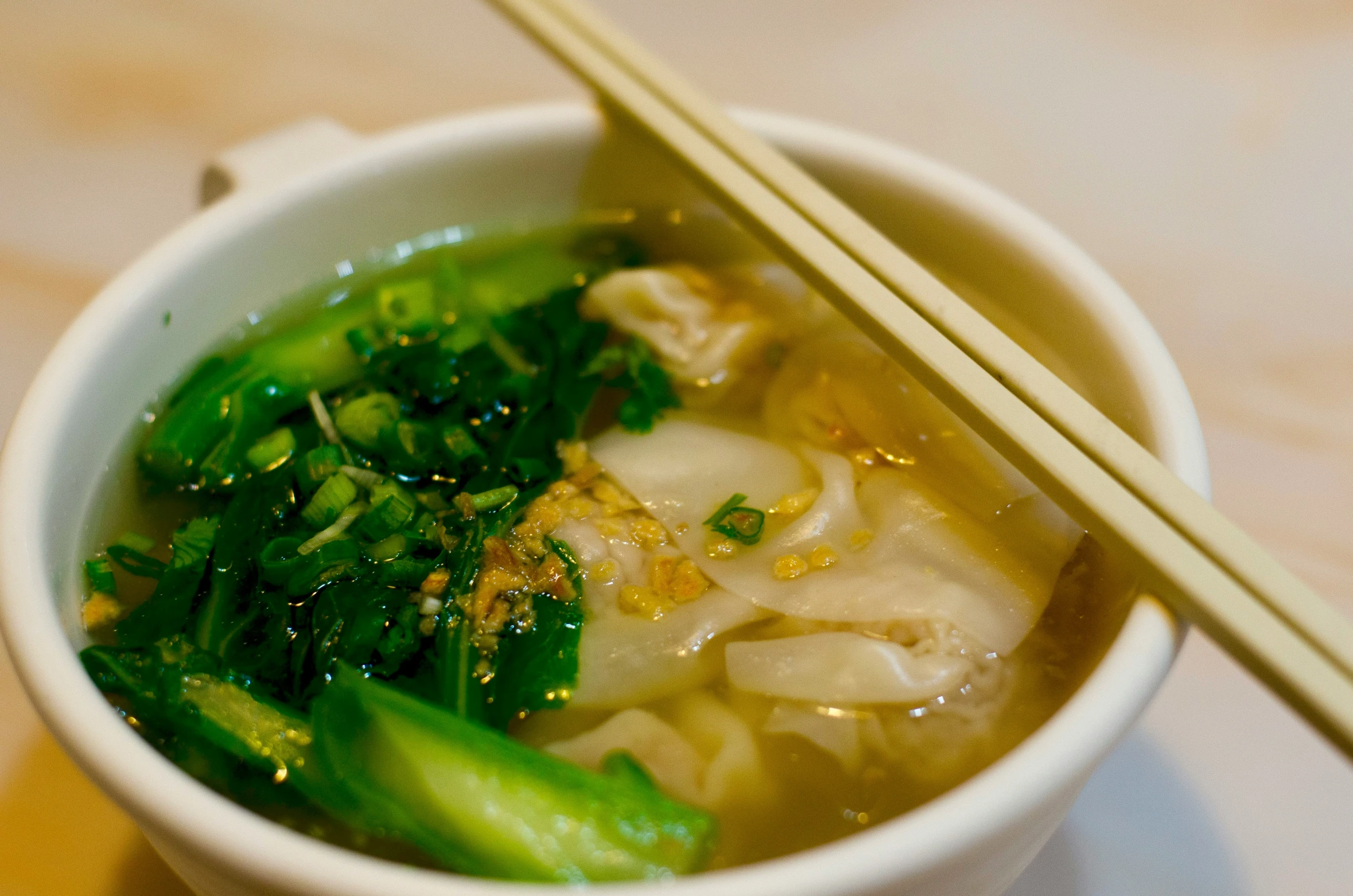 bowl with soup and chopsticks on table