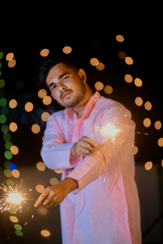 a man in a pink outfit holding some sparklers