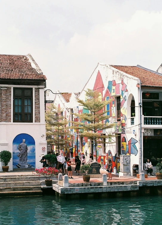 many people walk near buildings on a pier