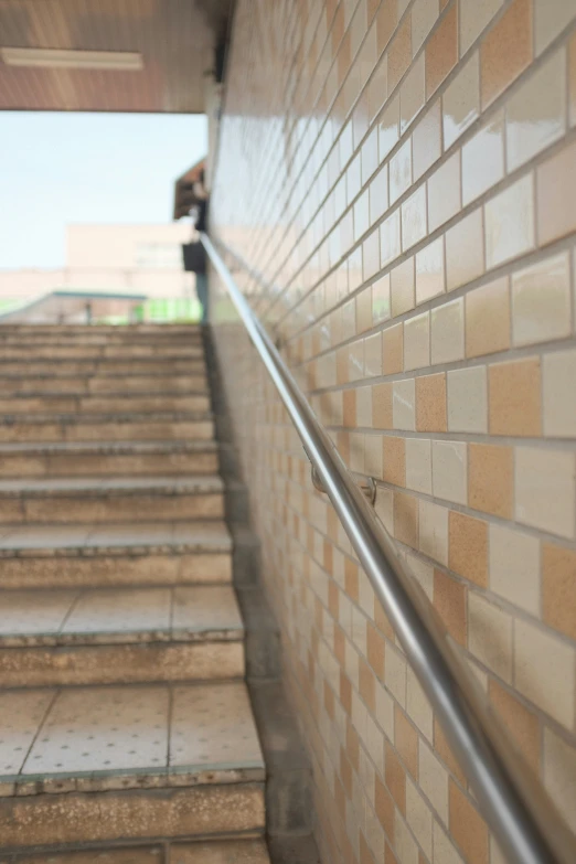 a long handrail is above tiled stairs