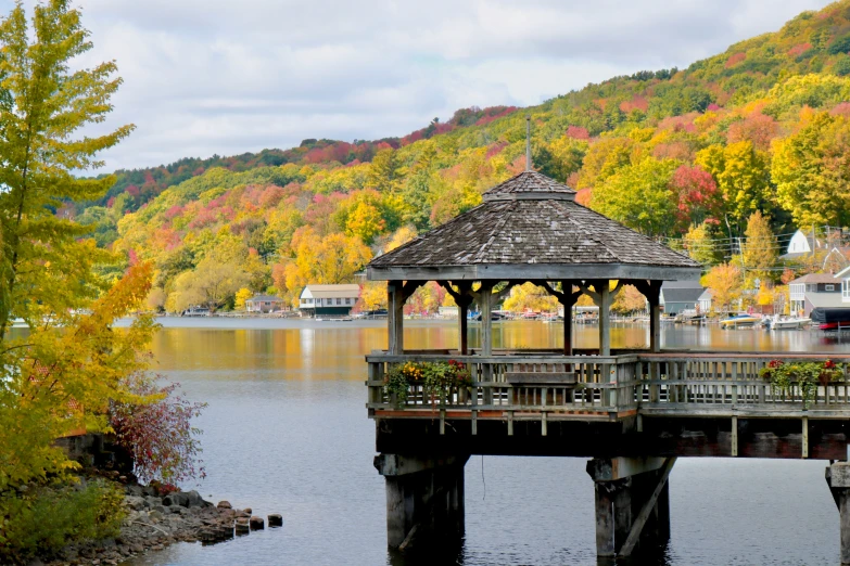 a gazebo sitting on the side of a wooden pier