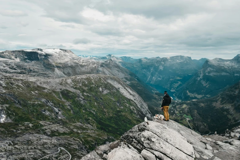 two men are standing at the top of a mountain overlooking mountains