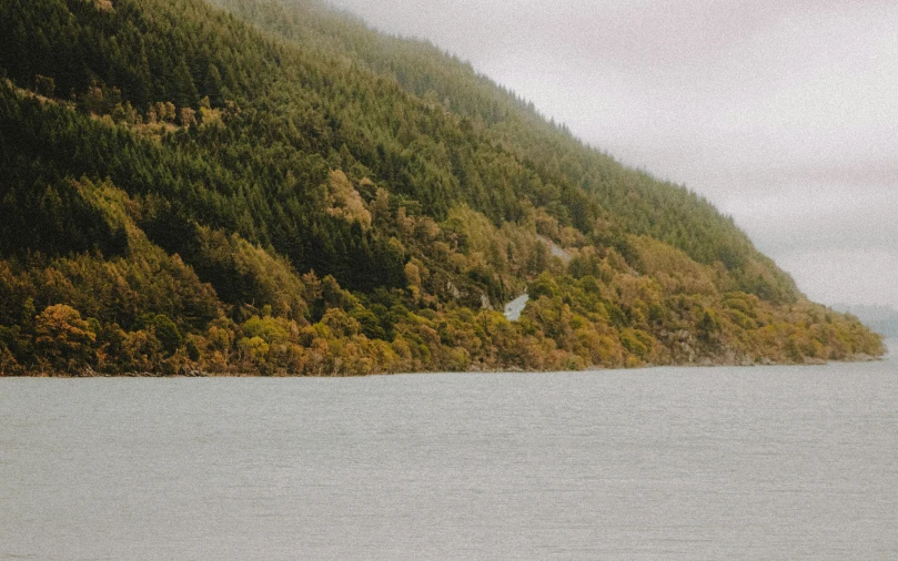 a boat sitting at the edge of a mountain lake