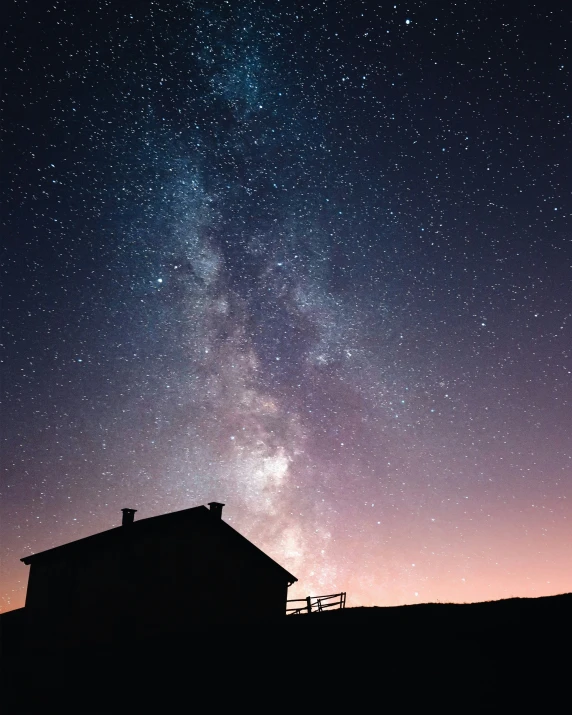 the milky hangs over a house at night