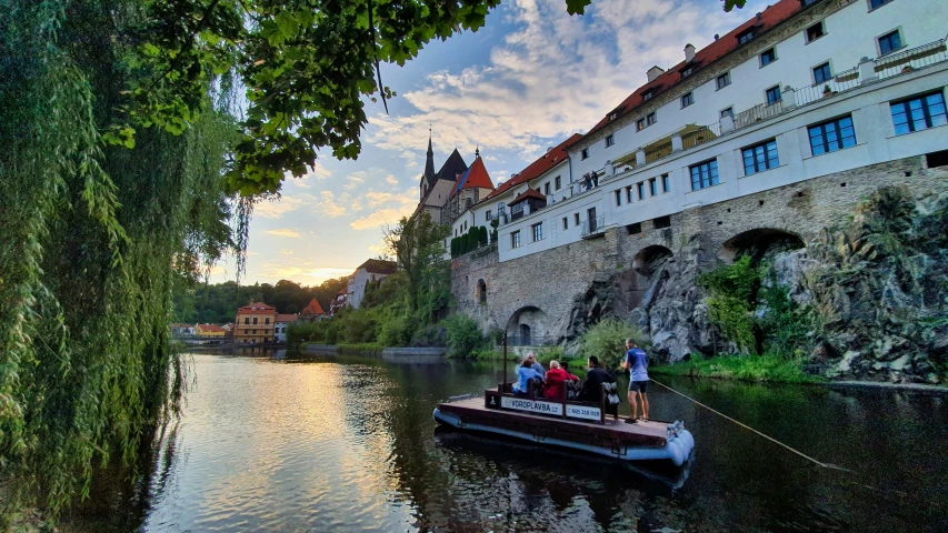 people are riding in a small boat down the river