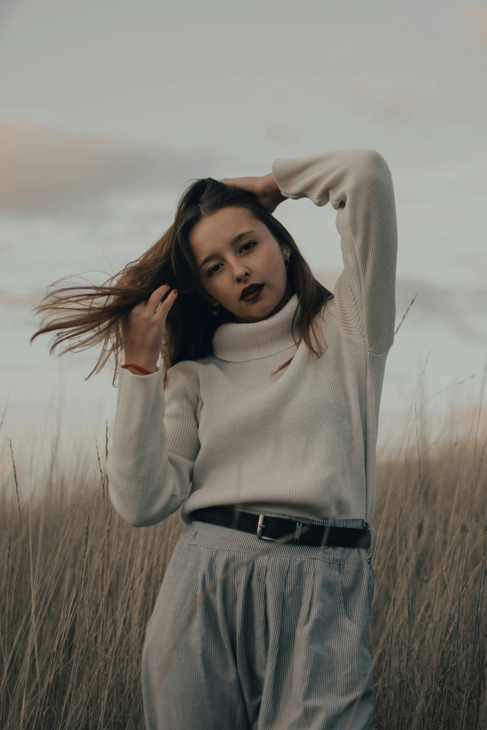 a woman is posing in the grass for a pograph