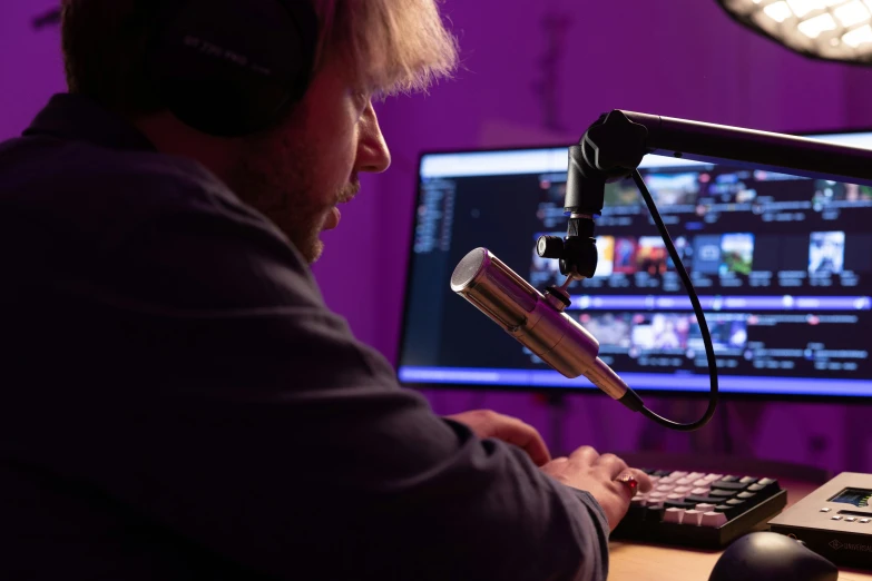 man in the radio station with headphones in front of a microphone