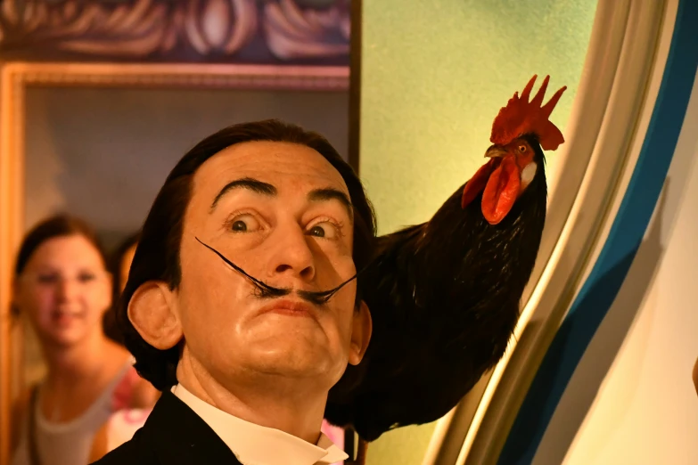 a close - up of a man wearing a fake head with a chicken in his mouth