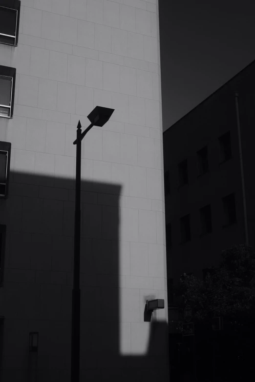 a tall street light near a building and some windows